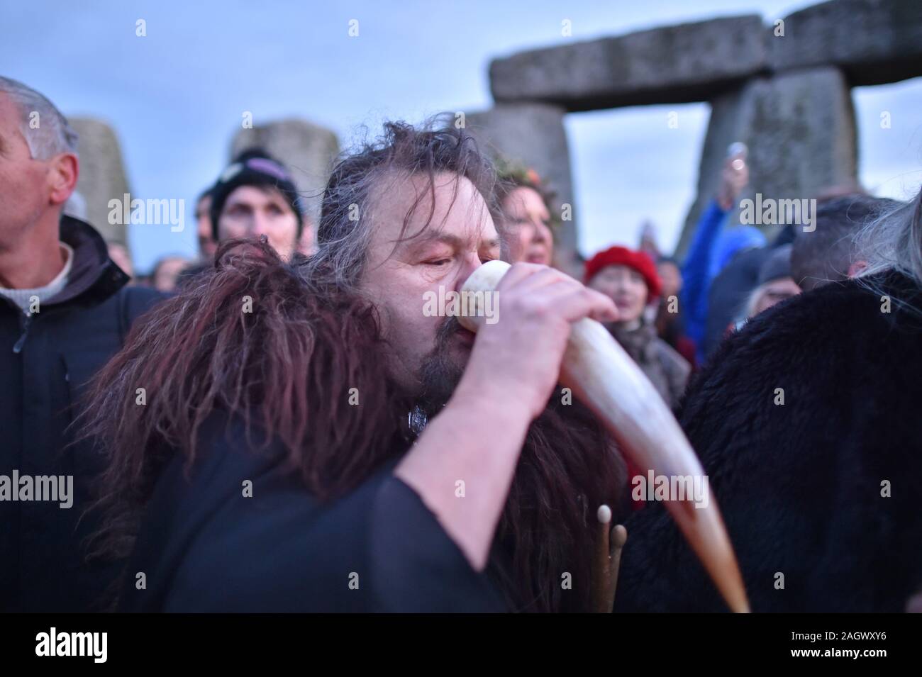 Un homme boit de l'hydromel à partir d'un animal à l'intérieur de la corne à Stonehenge le cercle de pierre dans le Wiltshire pour marquer le solstice d'hiver. Banque D'Images