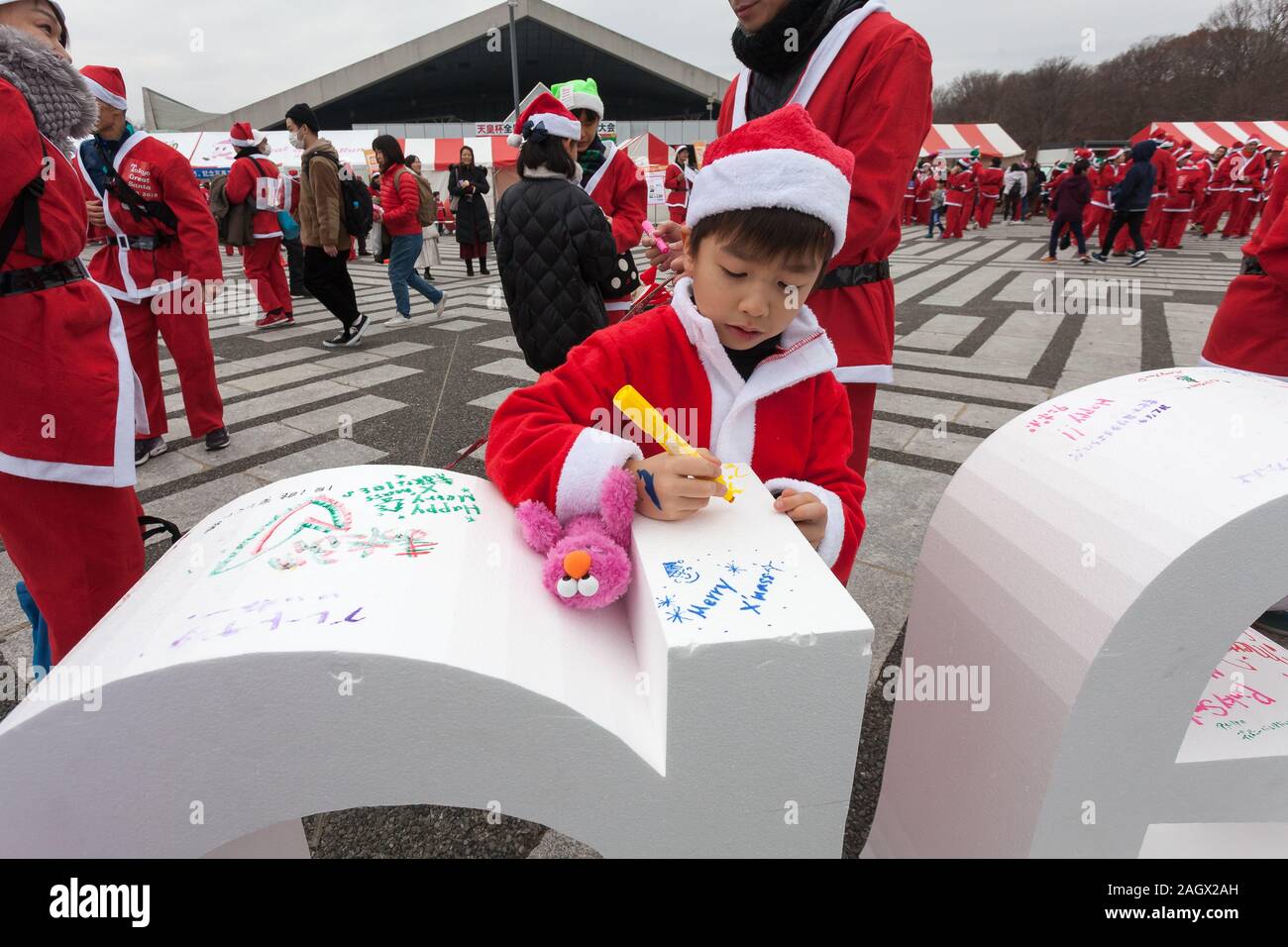 Les participants écrivent des messages de Noël sur de grosses lettres orthographe 'Santa' avant de prendre part à la Grande Course de Tokyo Santa dans le Parc Olympique Komazawa-daigaku, Tokyo, Japon. Dimanche 22 décembre 2019, le grand père était d'abord exécuter à Tokyo en 2018. Cette années a vu plus de 3 000 personnes à Santa costumes course et marche un kilomètre 4,3 cours pour recueillir des fonds pour les organismes de bienfaisance enregistrés au Japon et de l'eau pour des projets les Massaï au Kenya. Banque D'Images