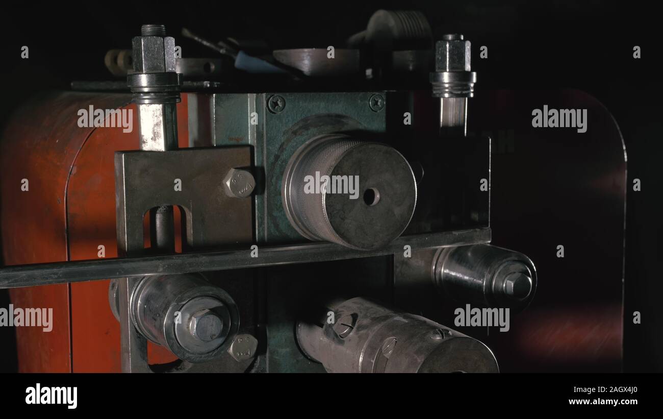 Aller de l'atelier sur la table. Coudes travailleur la tige de métal sur le pliage de la ronde en fer forgé. Fabrication d'un designer partie d'une tige métallique. Banque D'Images