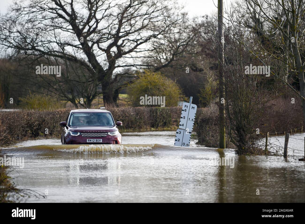Lewes UK 22 décembre 2019 - une voiture négocie une route inondée dans le village de Barcombe Mills near Lewes comme plus de météo et des avertissements ont été émis en Grande-Bretagne après des jours de pluie Crédit : Simon Dack / Alamy Live News Banque D'Images