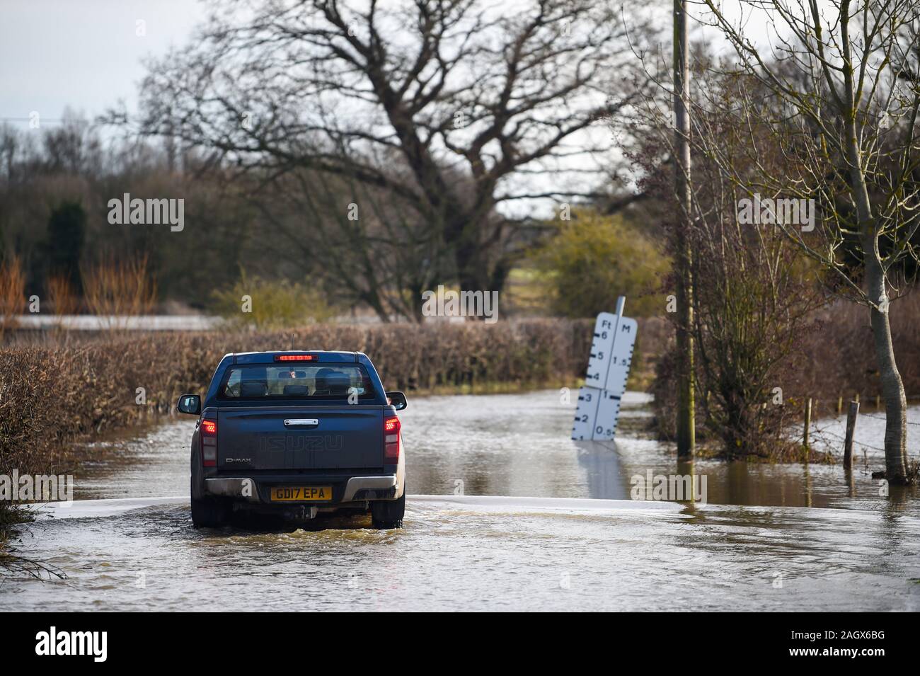 Lewes UK 22 décembre 2019 - une voiture négocie une route inondée dans le village de Barcombe Mills near Lewes comme plus de météo et des avertissements ont été émis en Grande-Bretagne après des jours de pluie Crédit : Simon Dack / Alamy Live News Banque D'Images