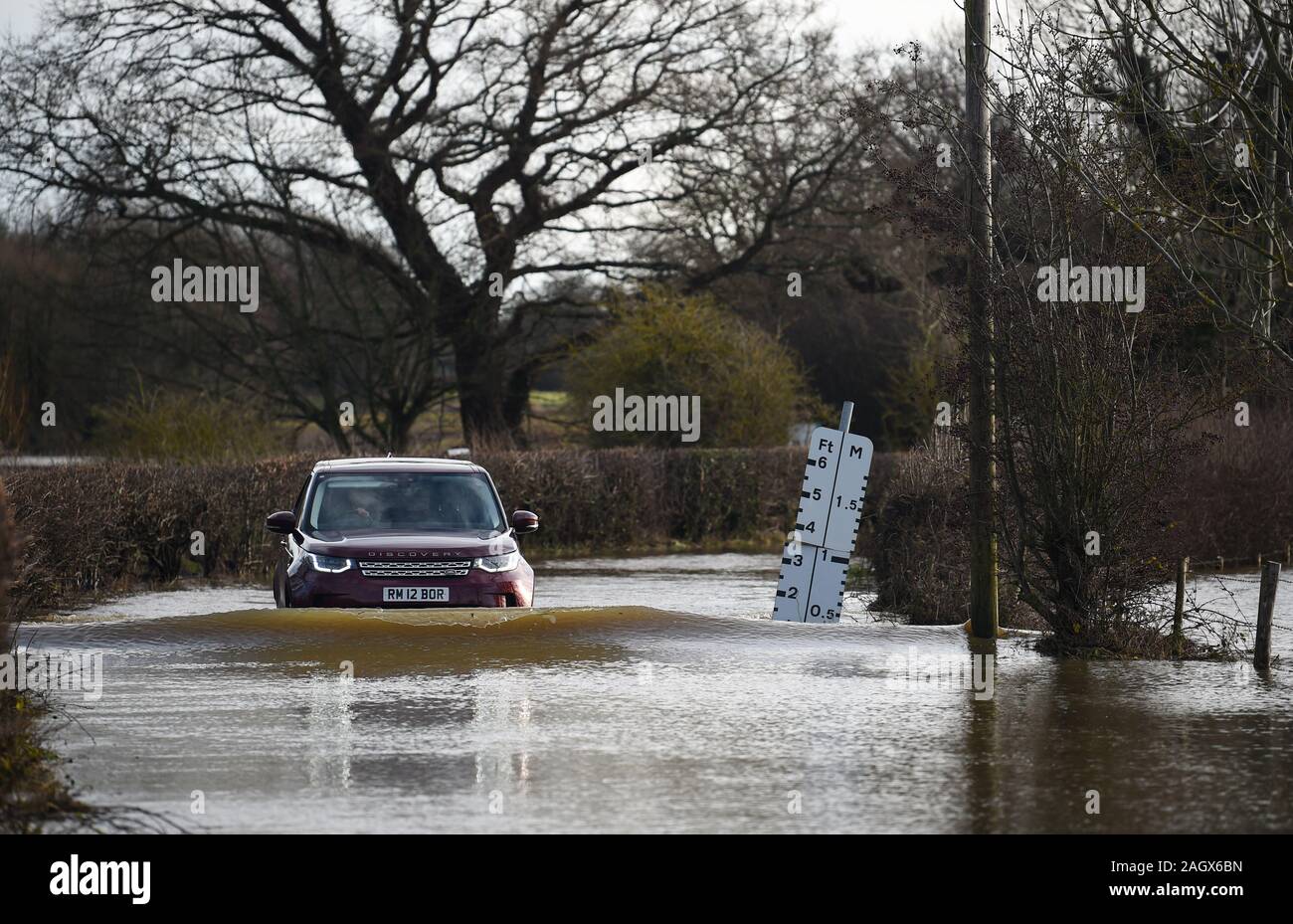 Lewes UK 22 décembre 2019 - une voiture négocie une route inondée dans le village de Barcombe Mills near Lewes comme plus de météo et des avertissements ont été émis en Grande-Bretagne après des jours de pluie Crédit : Simon Dack / Alamy Live News Banque D'Images