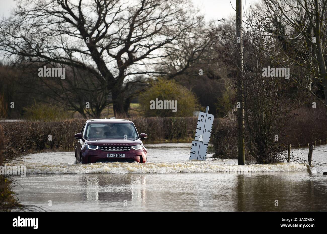 Lewes UK 22 décembre 2019 - une voiture négocie une route inondée dans le village de Barcombe Mills near Lewes comme plus de météo et des avertissements ont été émis en Grande-Bretagne après des jours de pluie Crédit : Simon Dack / Alamy Live News Banque D'Images
