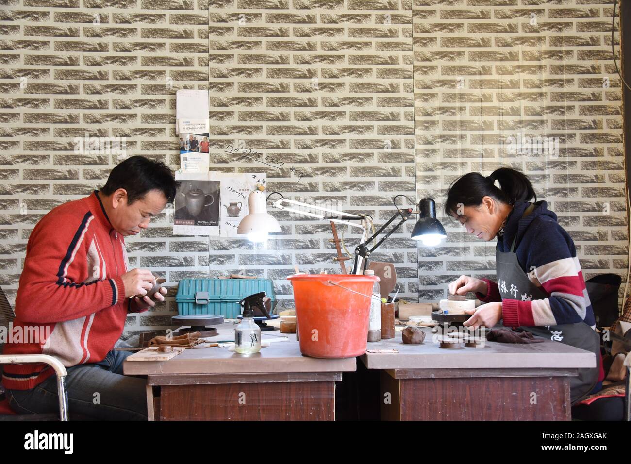(191222) -- YIAN, 22 déc., 2019 (Xinhua) ---devenu agriculteur artistes poterie Bai Yinjie (L) et son épouse Xu Mingjuan travailler sur des articles de poterie Argile violet dans un studio à Yian Comté de la province du nord-est de la Chine, 18 décembre 2019. Bai Yinjie et son épouse Xu Mingjuan, les deux 52, sont maintenant accrédités par province des maîtres de l'art de la poterie dans la région de Yian Comté. Ils ont utilisé pour être agriculteurs conventionnels les cultures dans le domaine, n'ayant pas de compétences liées à la poterie jusqu'en 2015. Yian comté a une réserve riche de kaolin, un matériel idéal pour la production de la poterie, mais il a longtemps été utilisé pour faire de grandes conta Banque D'Images