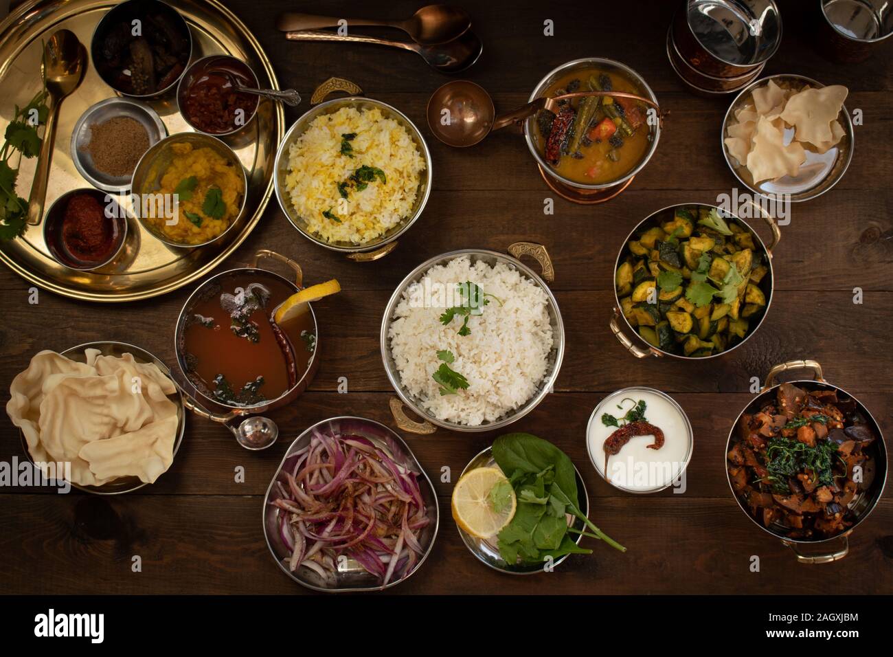 Variété de plats du sud de l'Inde sur une table en bois servi en cuivres traditionnels Banque D'Images