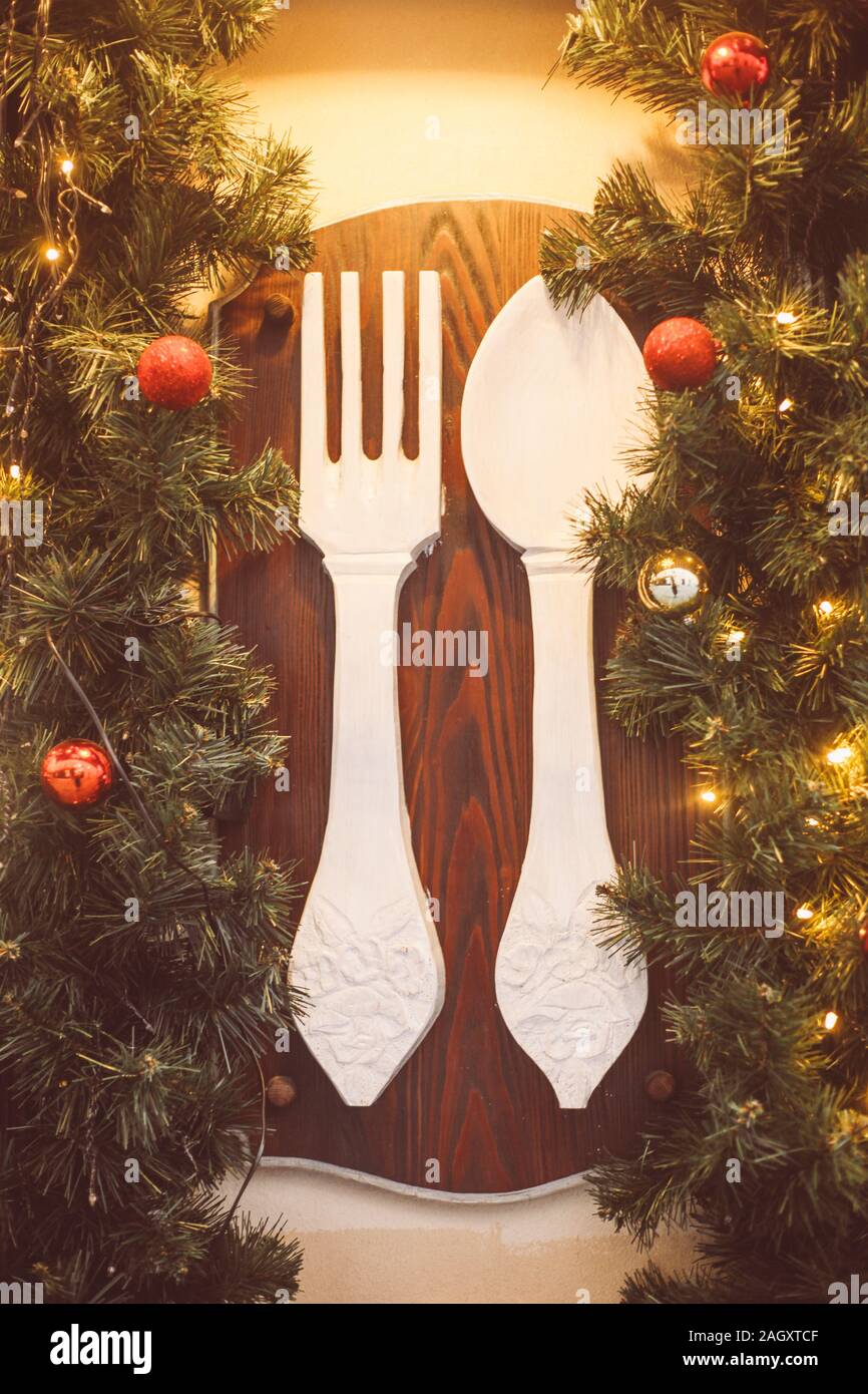 Décorées restaurant sign, fourchette et cuillère, couronne de Noël, faites de branches d'arbre, du décor, des ballons et des rubans, maison de vacances idée de conception Banque D'Images