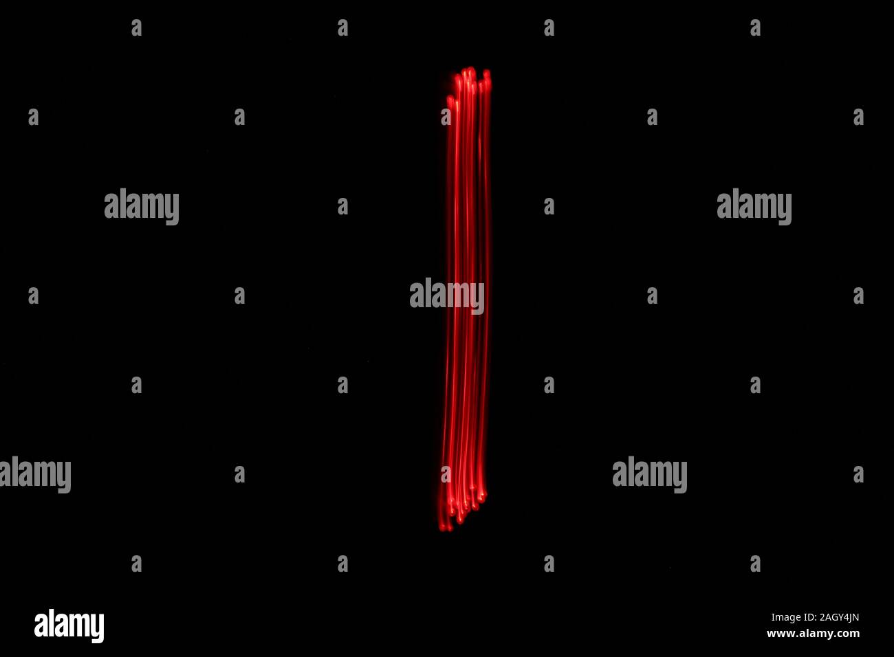Light painting photographie d'un certain nombre, dessiné par fairy lights en rouge couleur néon éclatantes sur un fond noir. Photos à longue exposition. Banque D'Images