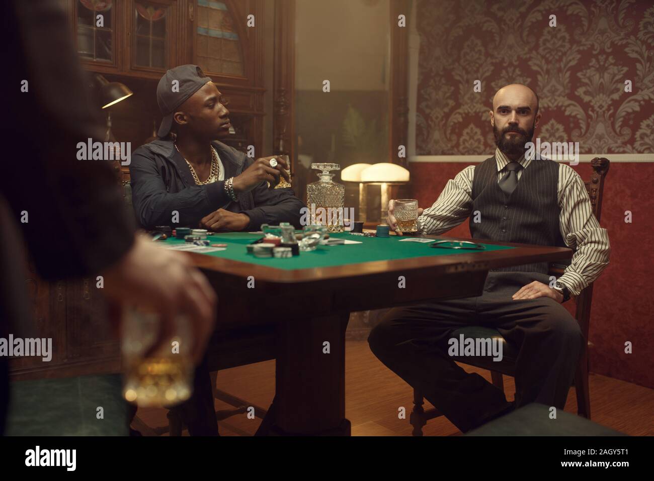Trois joueurs de poker avec du whisky et cigares Banque D'Images