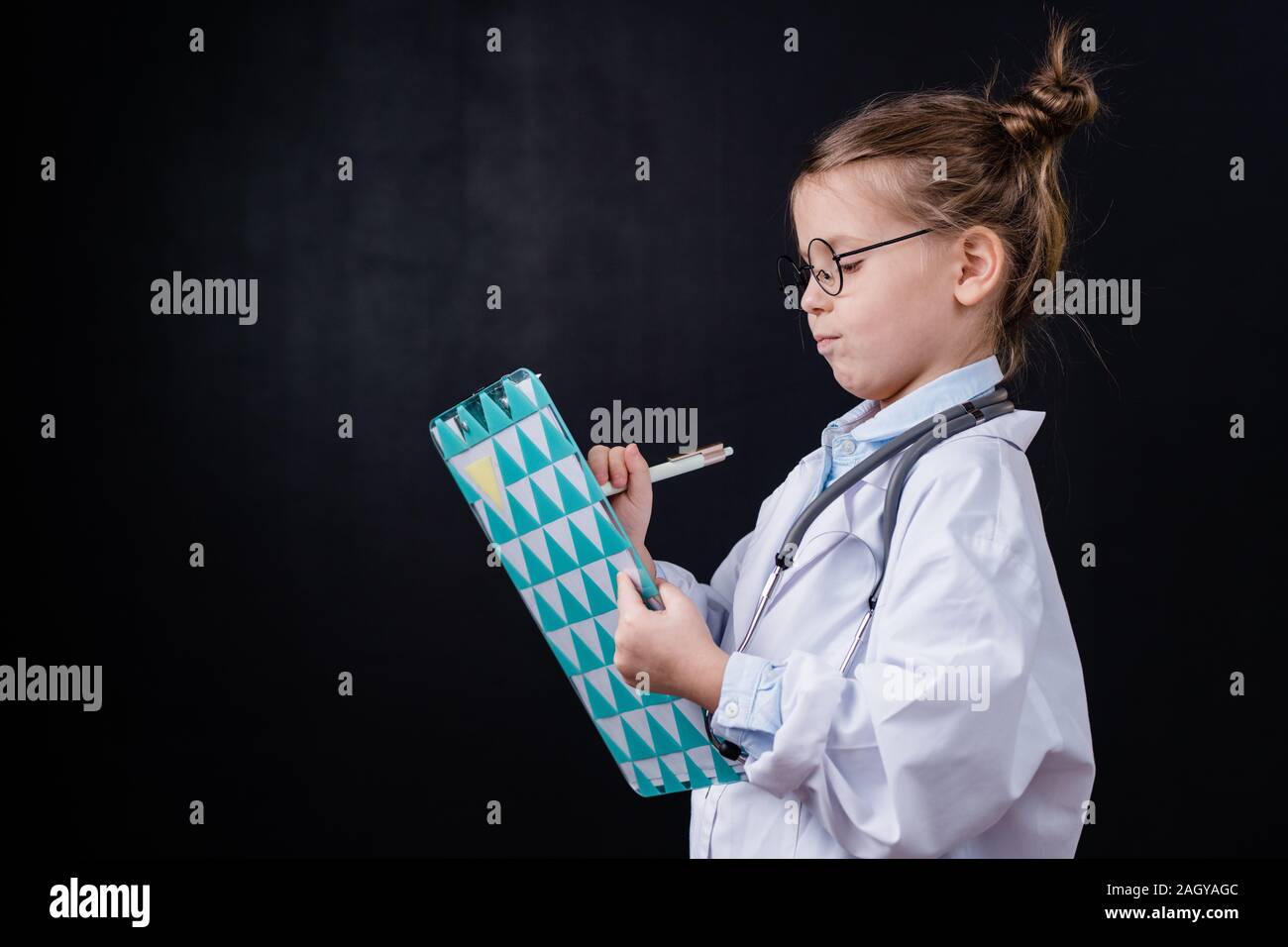 Adorable petite fille dans des blanchons prescriptions pour ses patients Banque D'Images