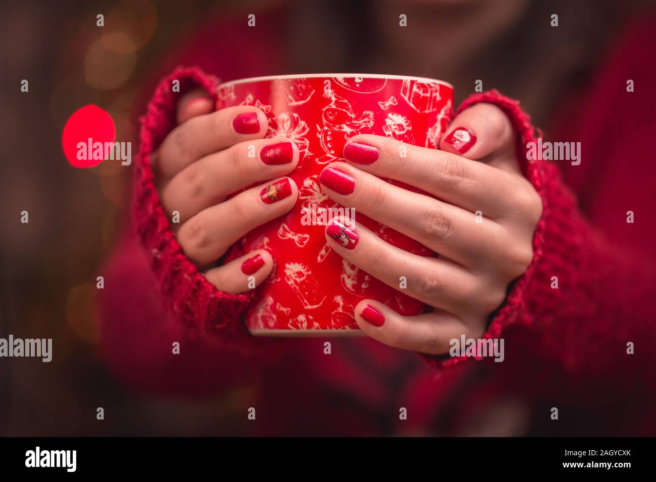 Woman's hand holding red une tasse de café. Avec une belle manucure d'hiver. Banque D'Images