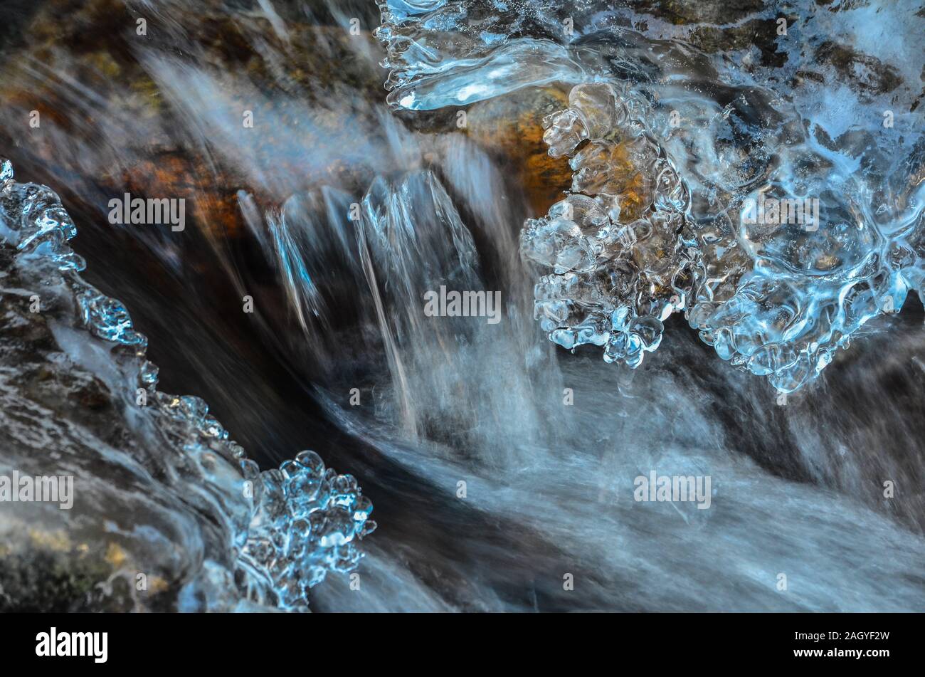 Détail de l'omble congelé - petite chute d'eau, la pierre, les glaçons et d'eau laiteuse Banque D'Images