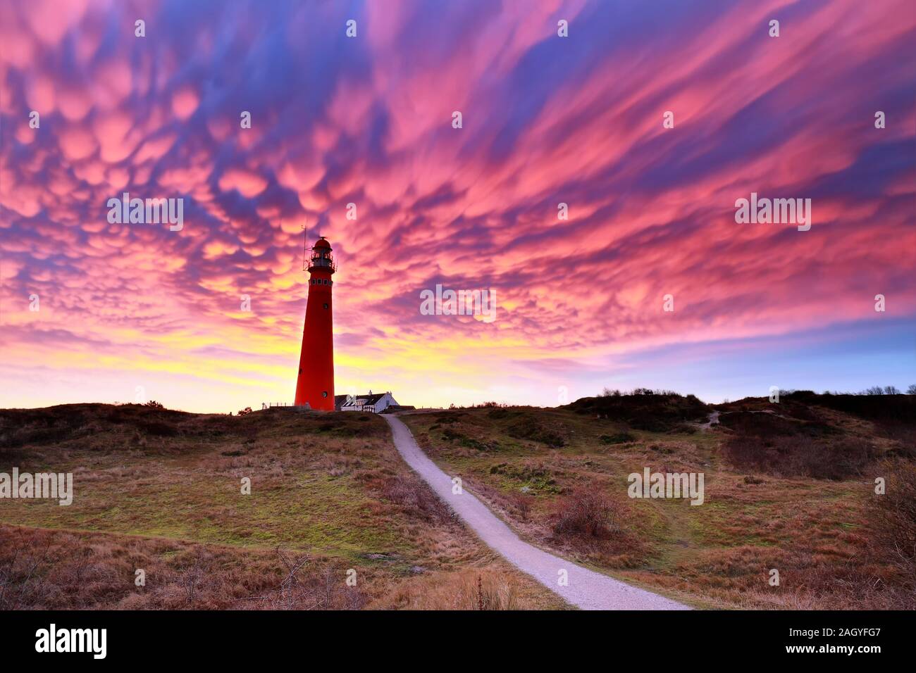 Les nuages mammatus pourpre spectaculaire plus de phare, Schiermonnikoog Banque D'Images