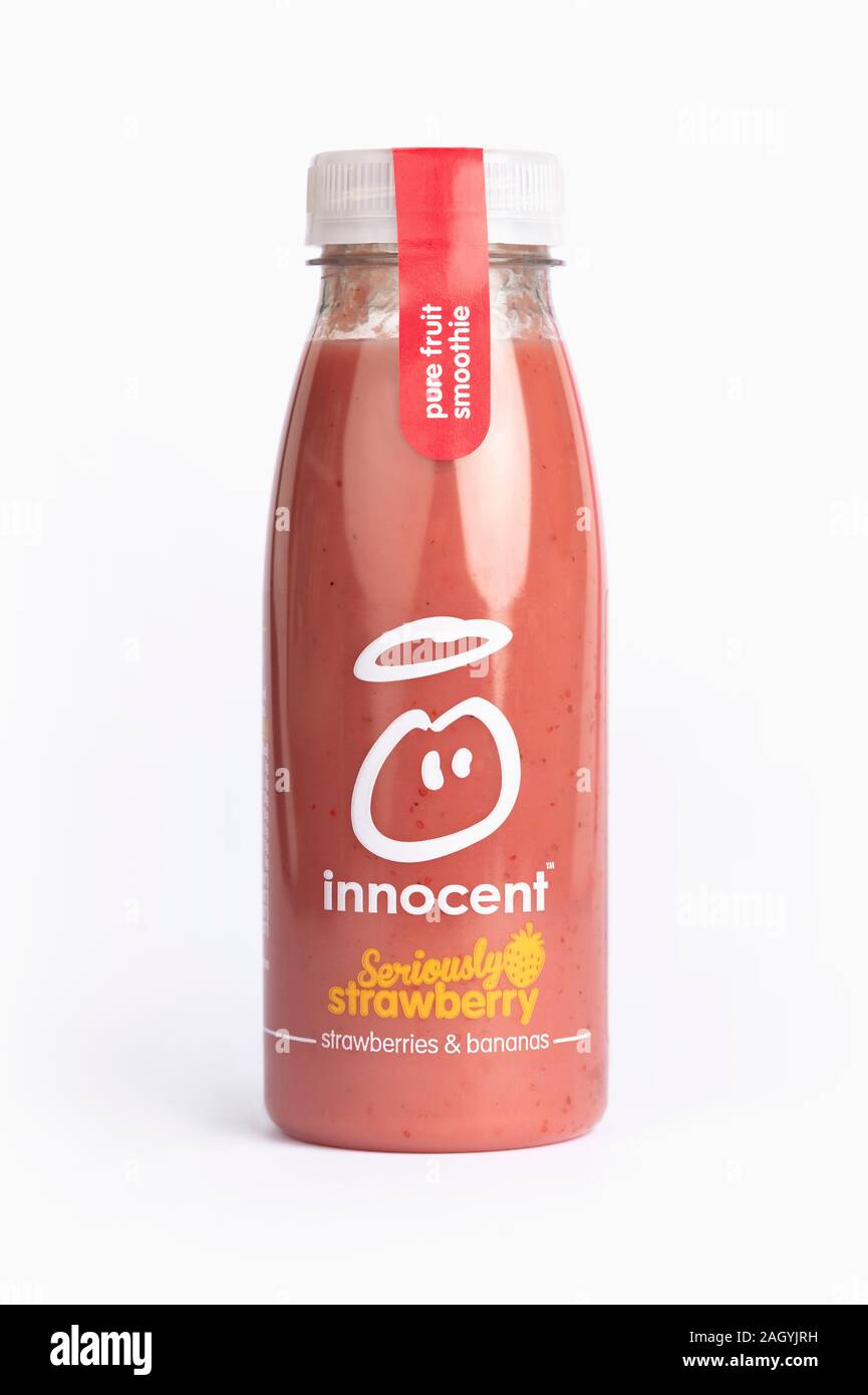 Une bouteille d'Innocent smoothie aux fraises sérieusement verre tourné sur un fond jaune. Banque D'Images