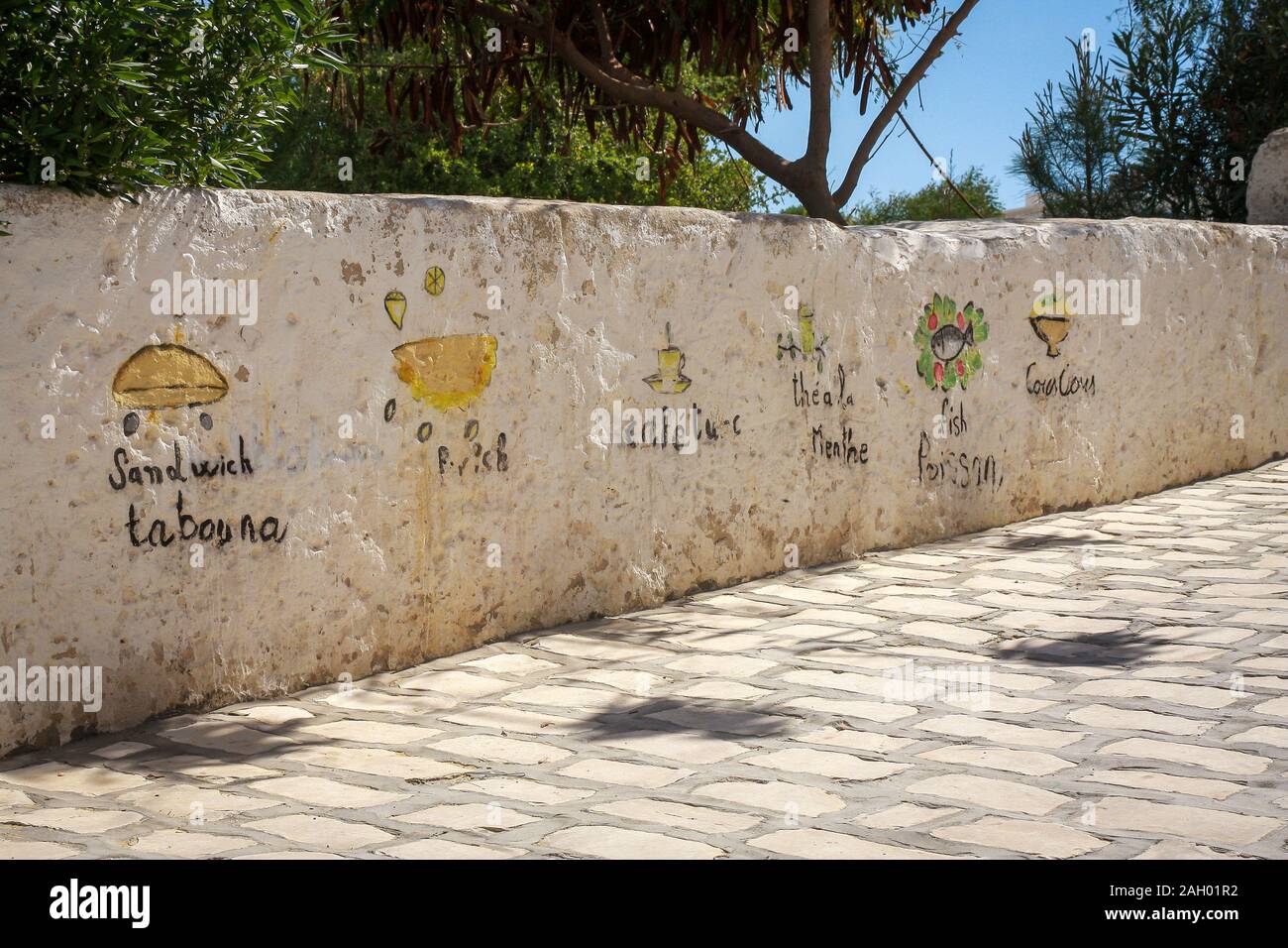 Menu peint à la main du restaurant voisin peint sur le mur à Hergla, Tunisie Banque D'Images