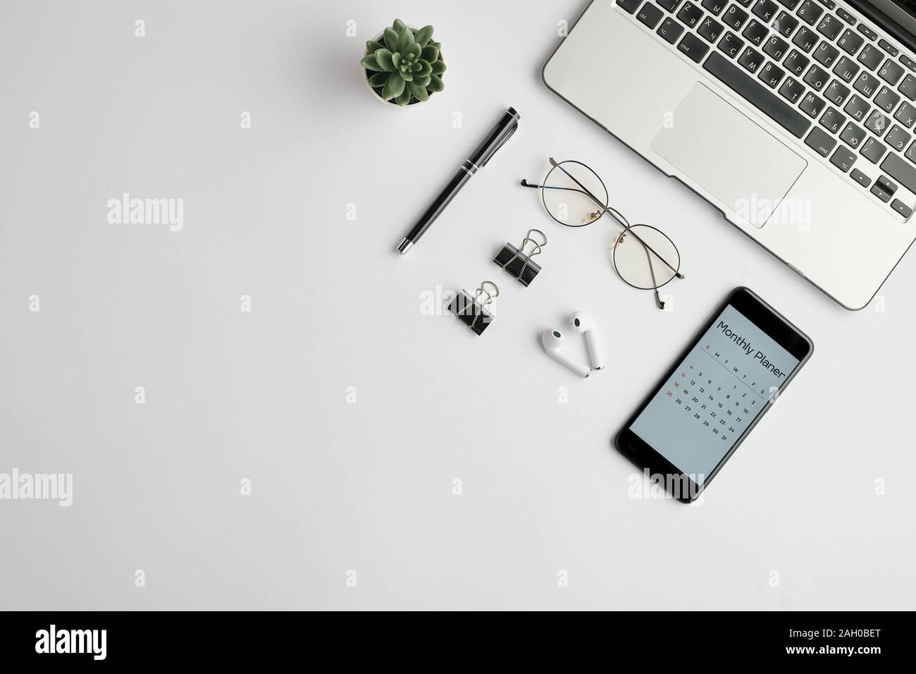 Écouteurs sans fil, lunettes, stylo, clips, planification mensuelle dans le téléphone et ordinateur portable Banque D'Images