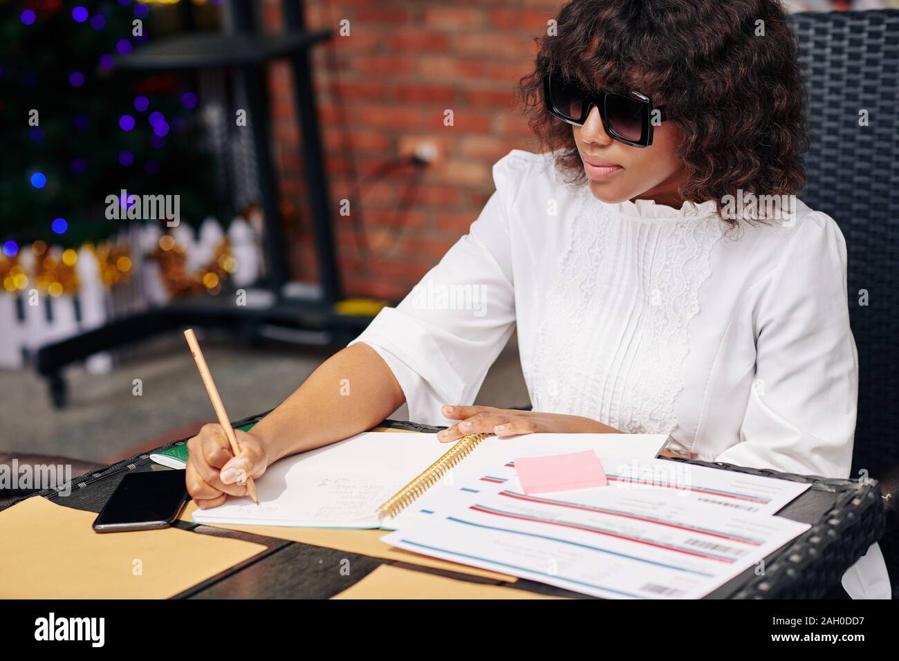 Portrait élégant grave les plans et liste de choses à faire en cas de travail à l'ordinateur portable cafe table avec les billets d'avion à l'avant sur son Banque D'Images