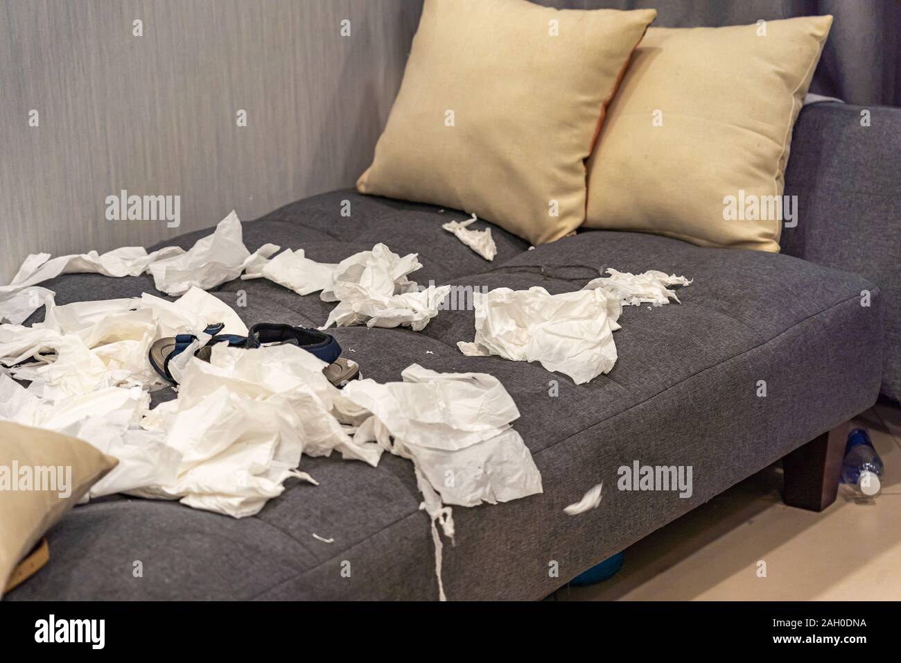 Messy salon avec pile de papiers tissu sur canapé Banque D'Images