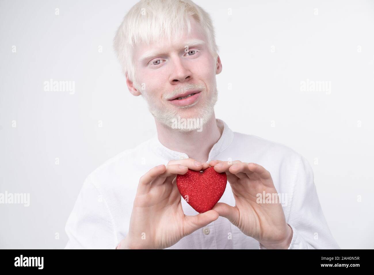 Portrait d'un homme albinos dans studio habillé t-shirt isolé sur un fond blanc. déviations anormales. Aspect insolite anomalie de la peau. Banque D'Images