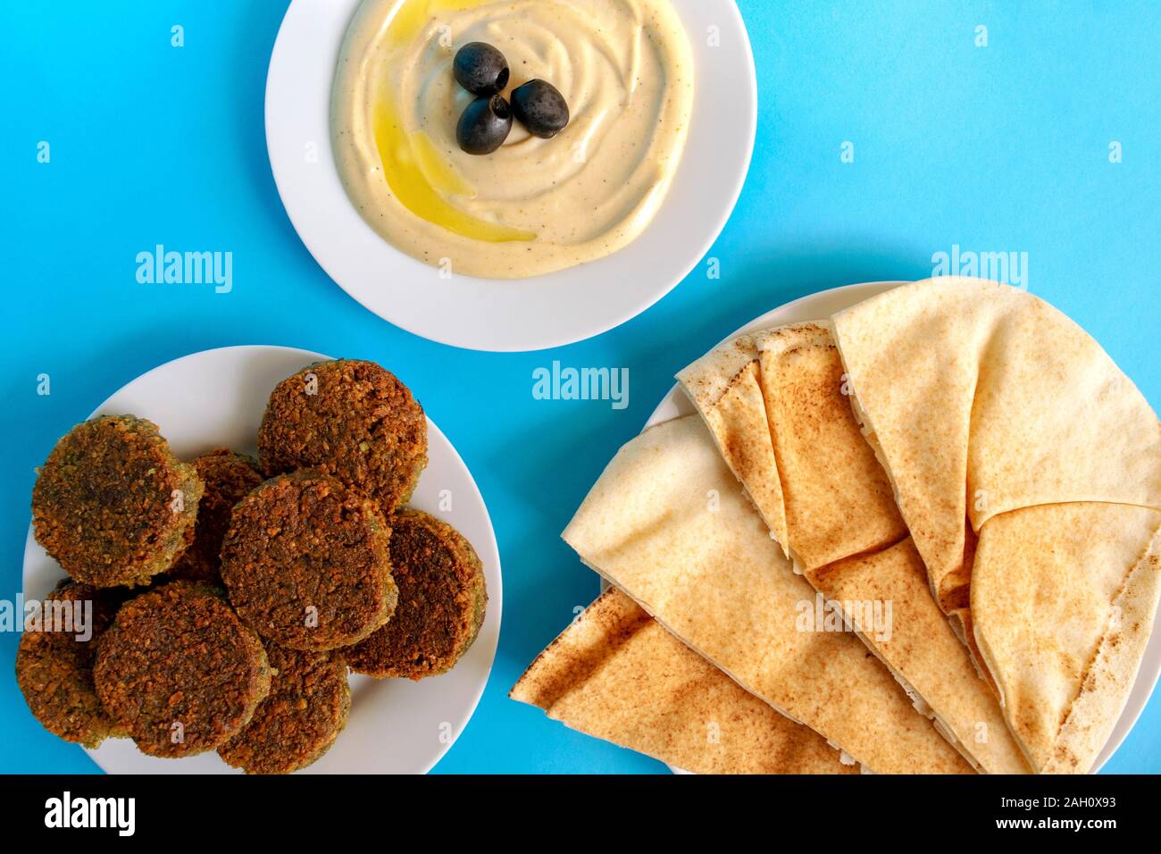 Célèbre cuisine arabe traditionnelle, Moyen-Orient, Israël. Tahina trempant, pain pita, et falafel sur fond bleu. Flat lay, vue de dessus. Nourriture Egipt. Banque D'Images