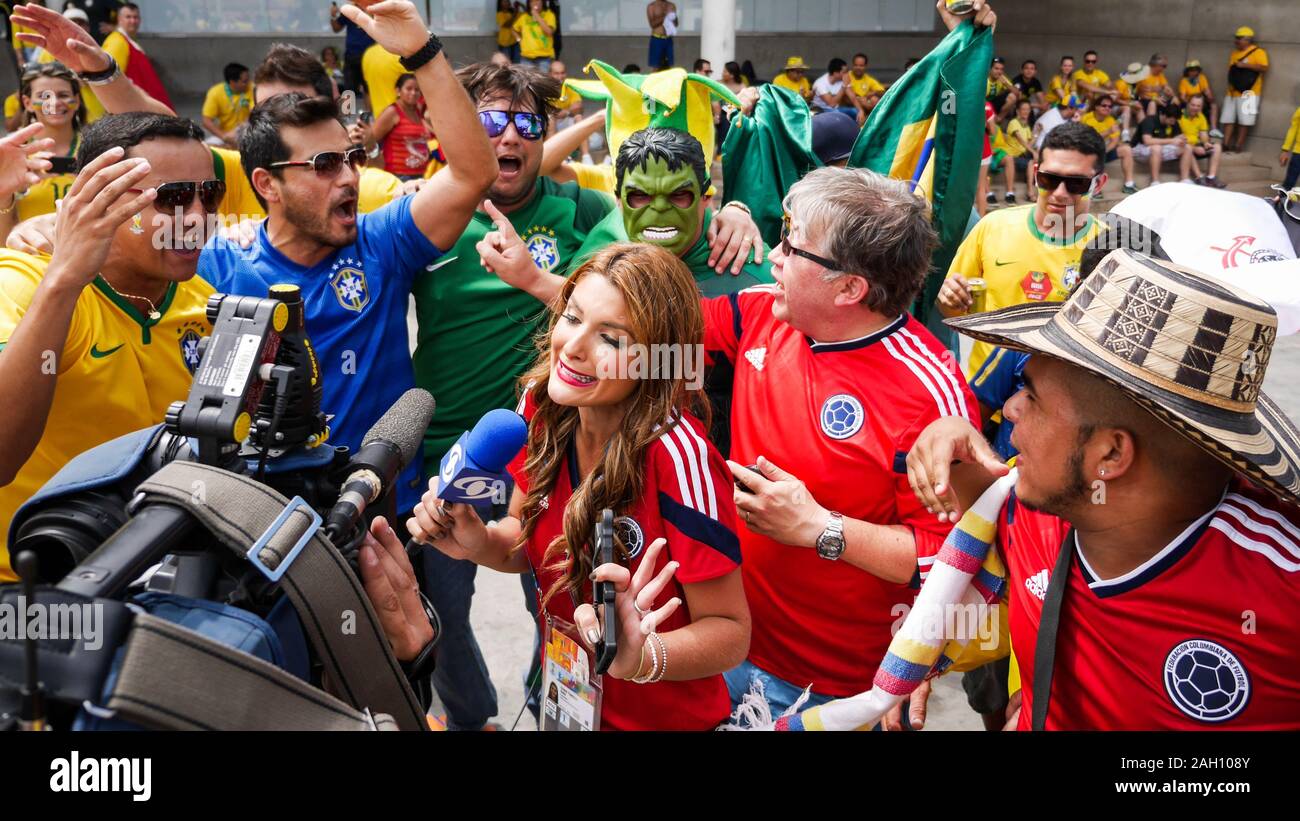 Un journaliste de la télévision colombienne de la difficulté à parler à huis clos, à un jeu de football entouré de rival amical et les fans de foot brésilien de la Colombie. Banque D'Images