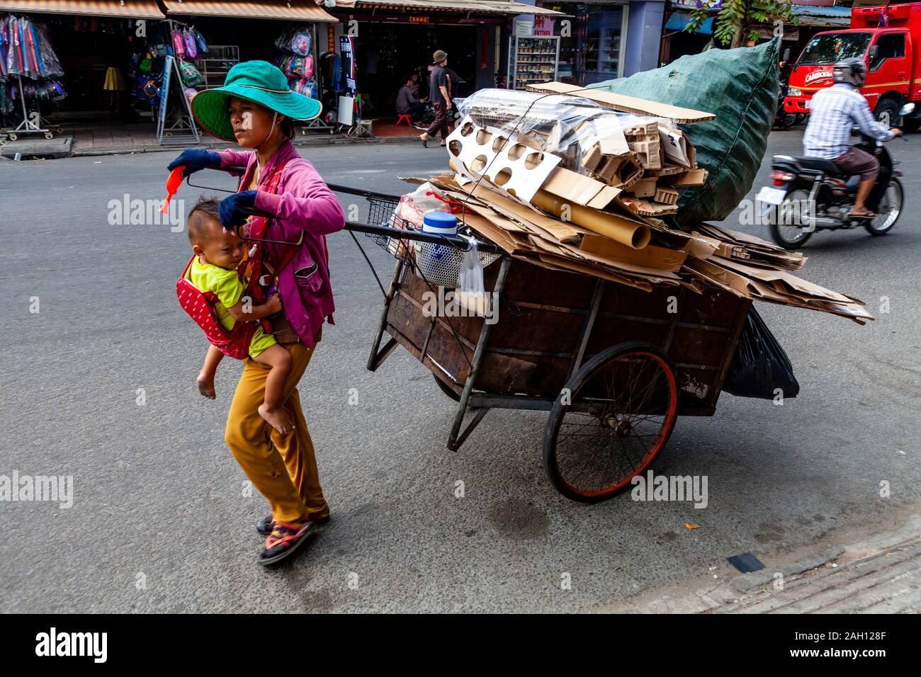 Une femme avec son enfant la collecte/transport de carton, Phnom Penh, Cambodge. Banque D'Images