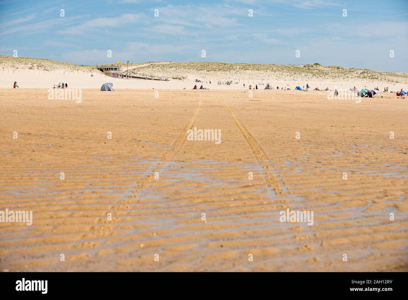 Plage avec sable humide et les dunes à l'arrière-plan Banque D'Images