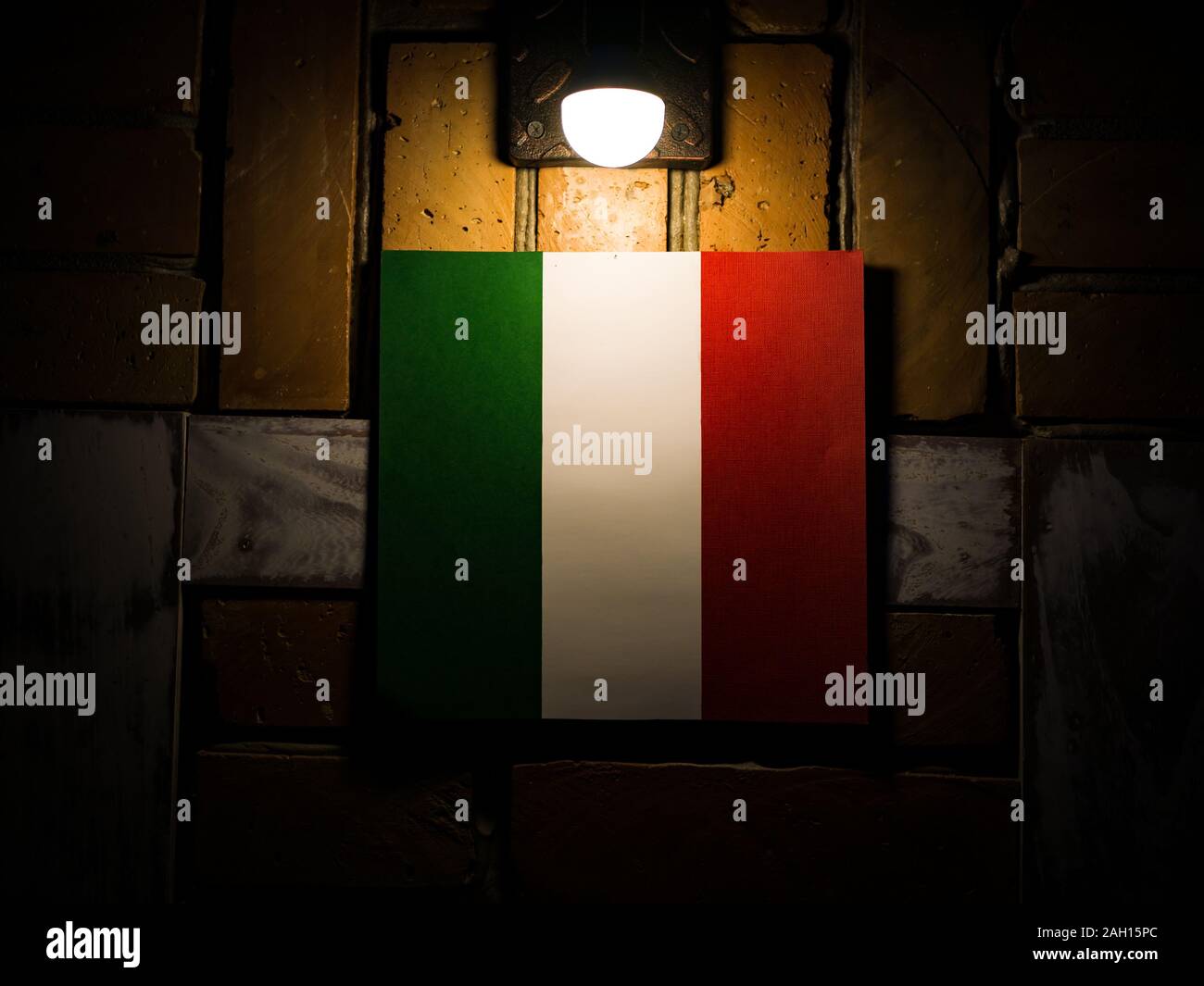 Drapeau Italien sur un mur de brique sous la lampe Banque D'Images