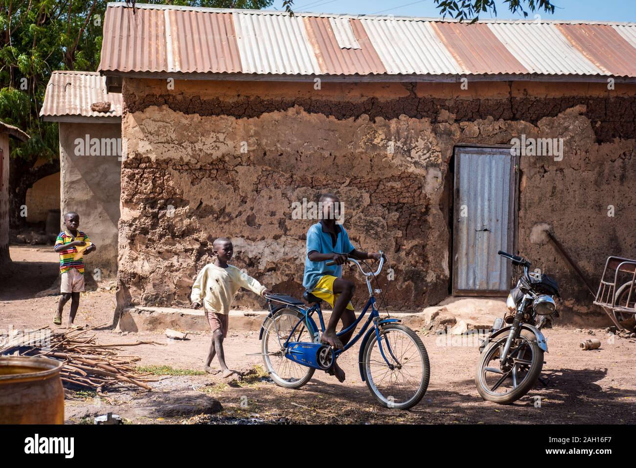 Le Bénin, Kandi, african boy, équitation, location de vélos, maison de terre, cour, village africain Banque D'Images