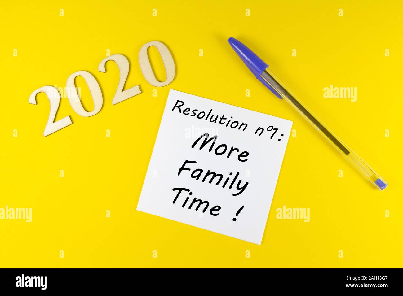 Stylo, papier à la résolution plus de temps en famille et en 2020 figures en bois sur fond jaune Banque D'Images