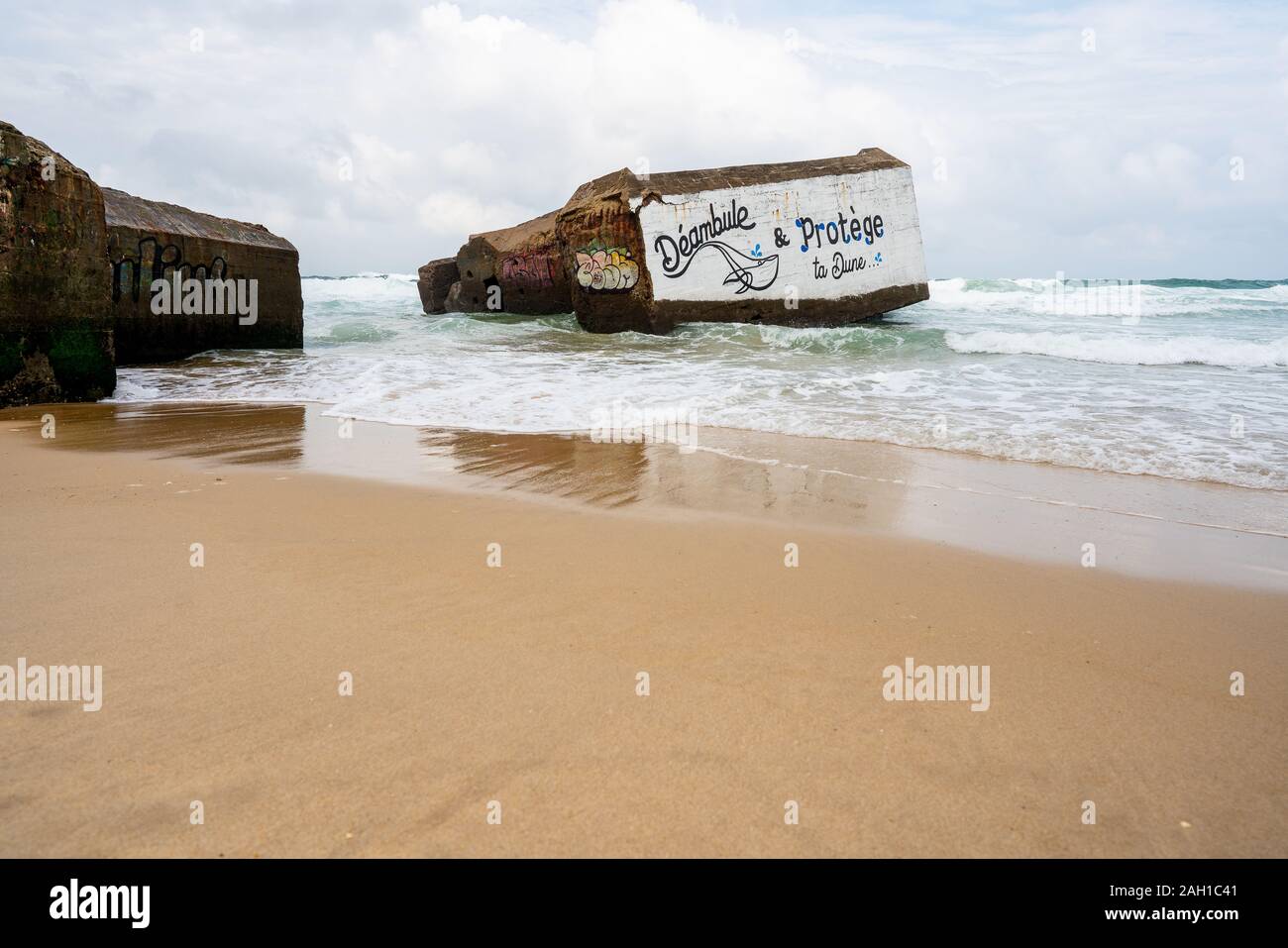 Guerre de bunkers de béton passé dans le shore break plage français Banque D'Images