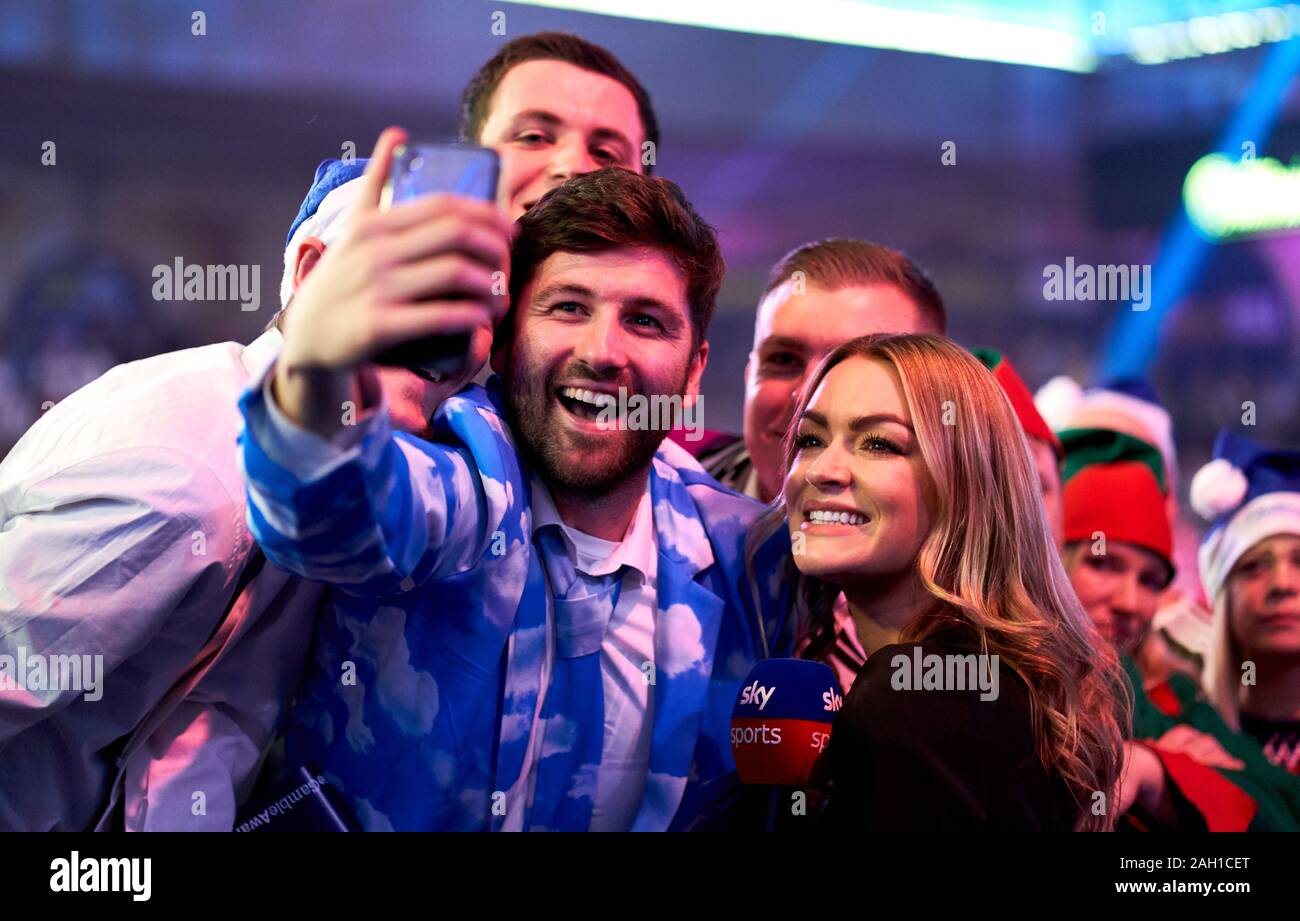 Laura Woods, sky sports présentateur pose pour une avec fléchettes selfies fans pendant onze jours du championnat du monde de William Hill à Alexandra Palace, Londres. Banque D'Images