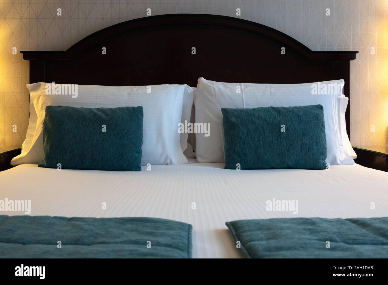 Chambre d'hôtel propre et confortable lit. Oreiller et couverture sur le  lit avec des lampes sur le côté dans une chambre de luxe Photo Stock - Alamy