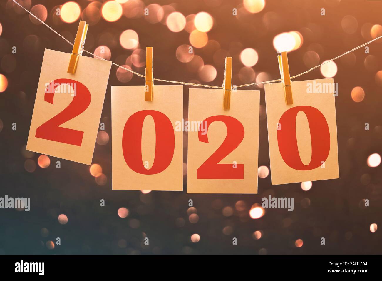 Nouvelle année 2020 cartes papier accroché sur une chaîne avec les Lumières floues en arrière-plan Banque D'Images
