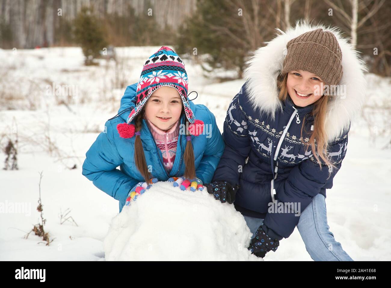 deux amies qui construisent un bonhomme de neige. des filles drôles sur une promenade en plein air en hiver. Banque D'Images
