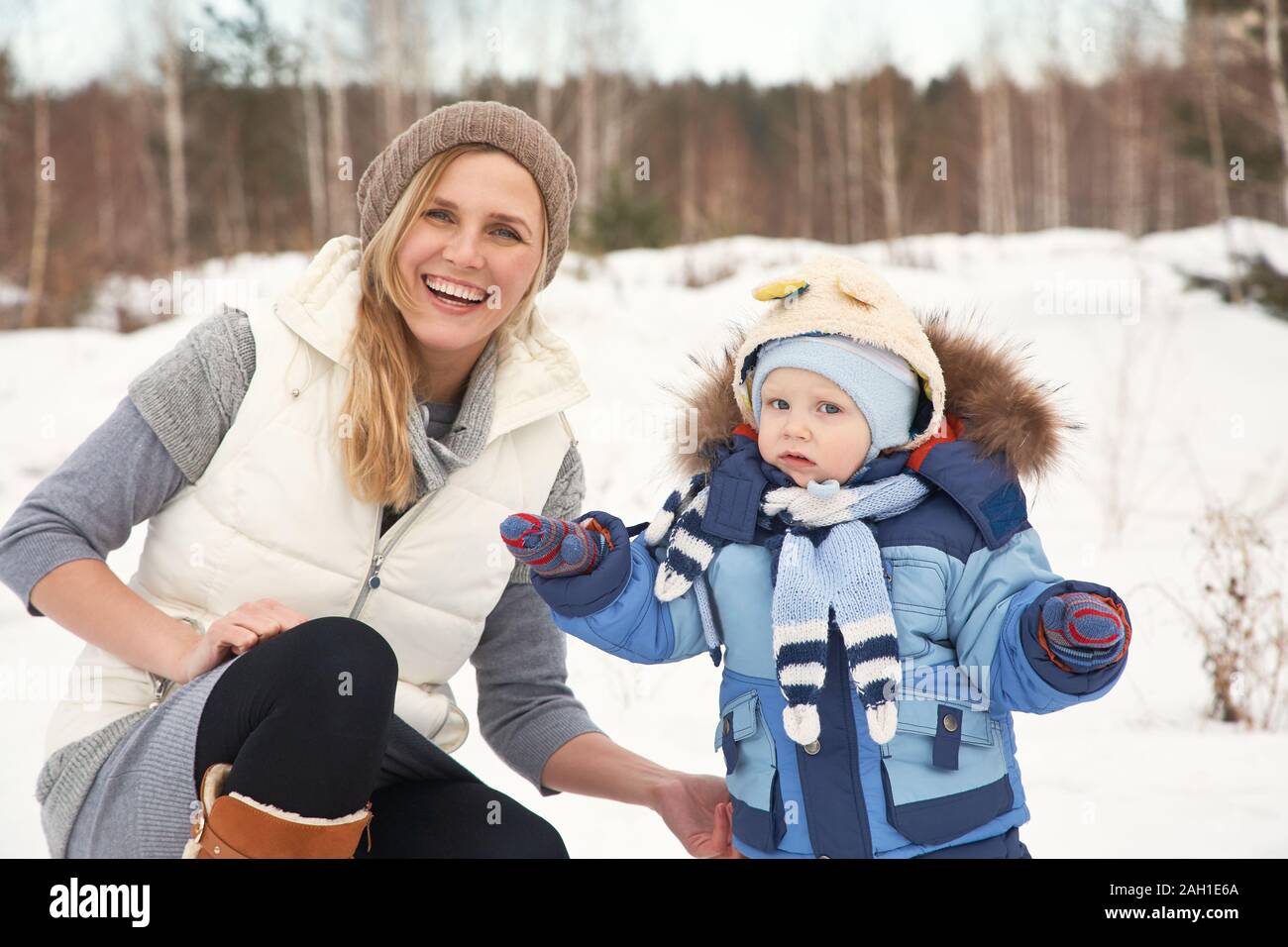 bonne mère et bébé dans le parc d'hiver. famille plein air. momie joyeuse avec son enfant. Banque D'Images