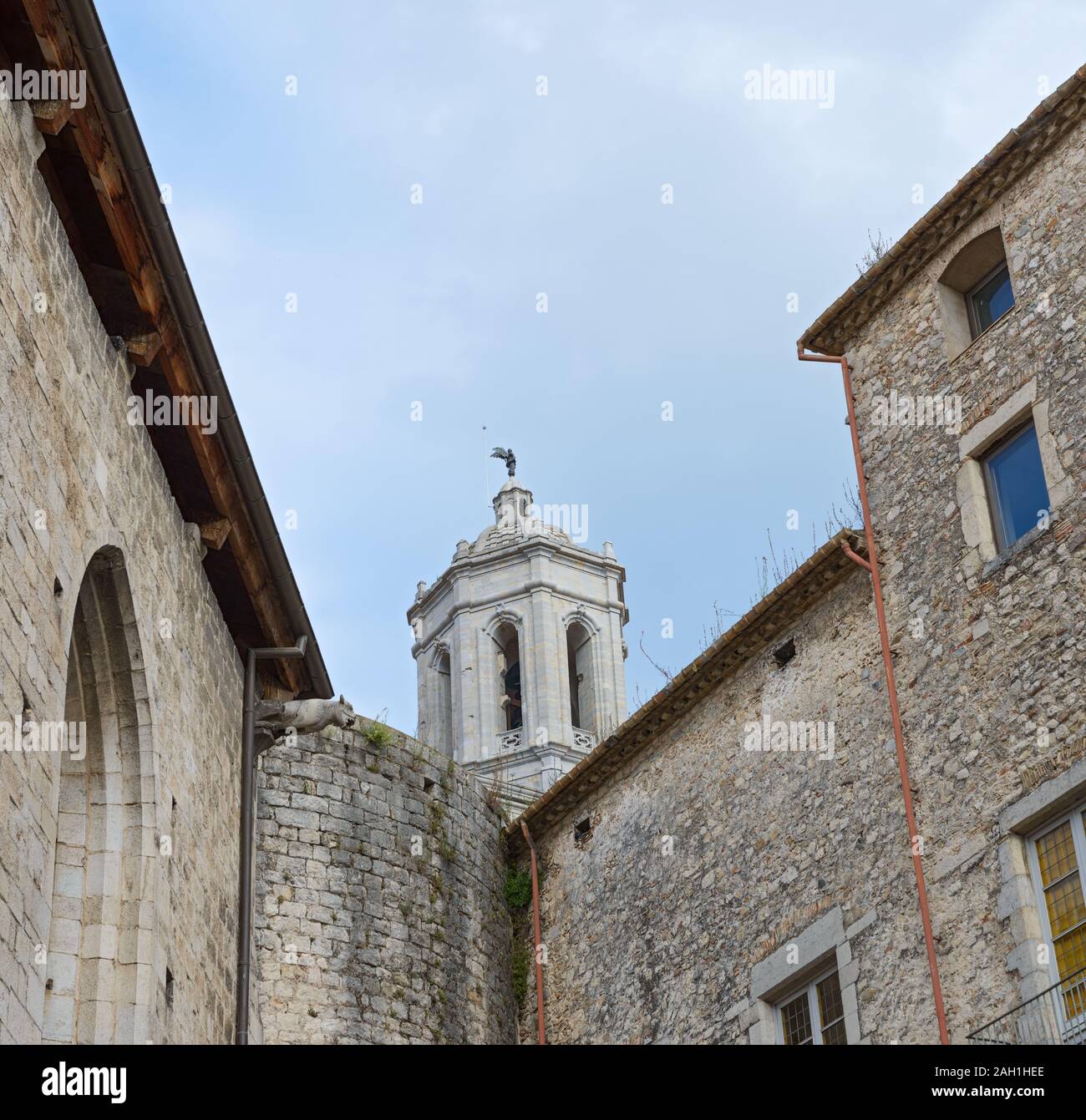 Vue sur le beffroi de la Cathédrale de Sainte Marie au-dessus de vieux murs en pierre du sud de l'angle de la Collégiale de Saint Félix de Gérone, Catalogne, Spai Banque D'Images