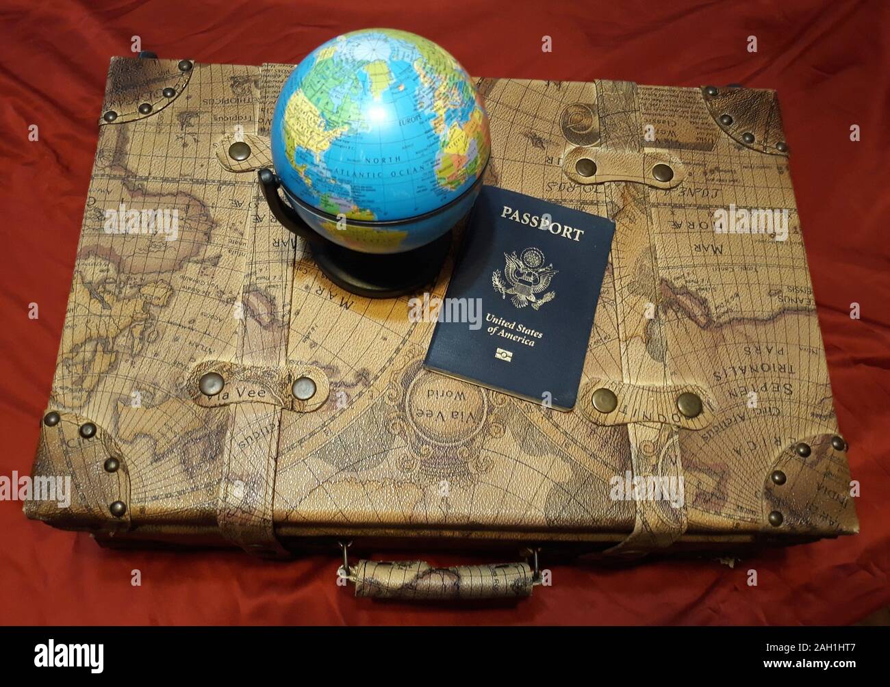 Vintage Voyage valise en cuir à thème avec un globe et passeport Banque D'Images