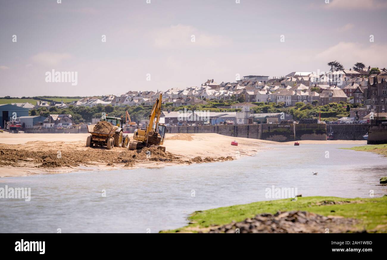 Les déménageurs de terre et les creuseurs dragage et déplacement du sable pour dégager un chenal dans la rivière Camel en regardant vers l'entrée du port de Padstow, Cornwall, Royaume-Uni. Banque D'Images