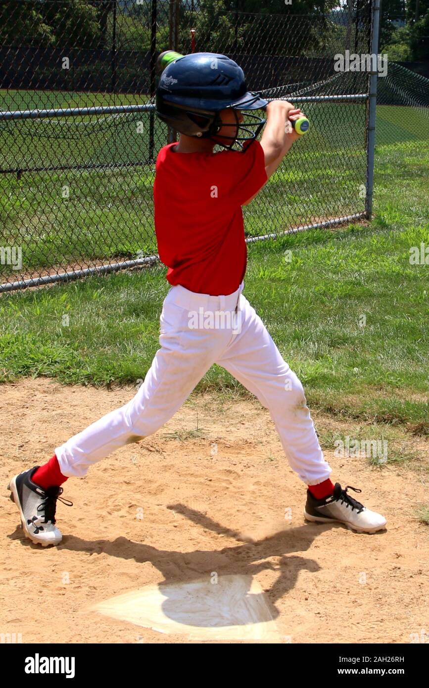Le joueur prend un swing avec sa batte de baseball. Banque D'Images