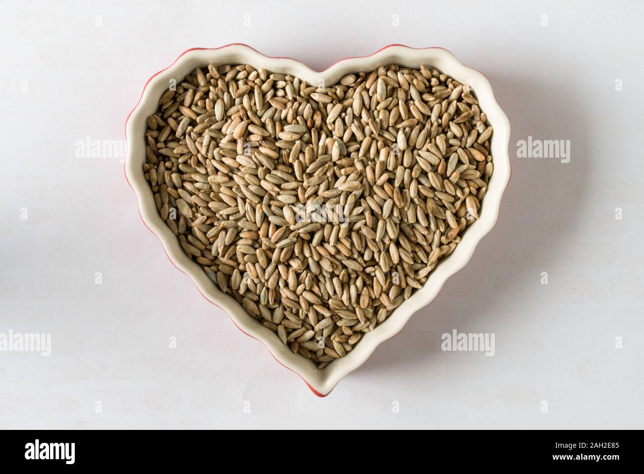 Mouture de grains entiers baies de seigle en forme de coeur Banque D'Images