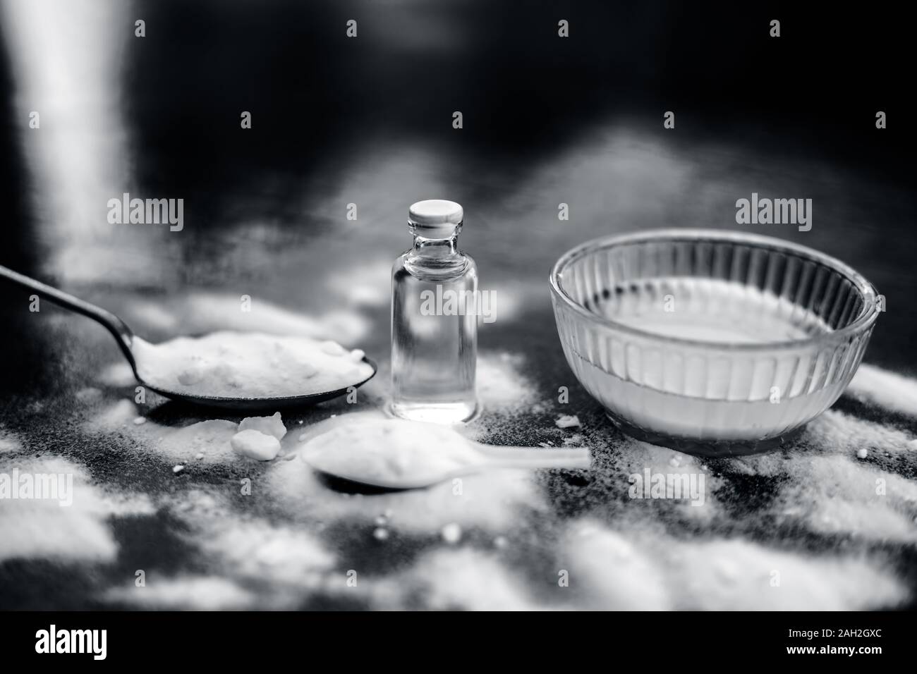 Masque de visage ou masque de bicarbonate de soude dans un bol en verre sur la surface en bois avec un peu de noix de coco en poudre et l'huile dans un flacon en verre transparent. Utilisé pour Banque D'Images