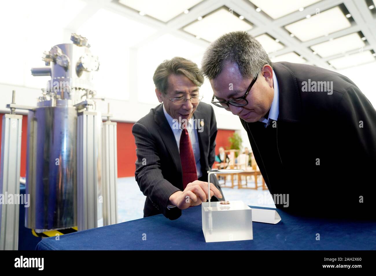 (191224) -- BEIJING, 24 décembre 2019 (Xinhua) -- Le professeur Xue Qikun (L) de l'Université Tsinghua et l'Académie chinoise des sciences, l'académicien, introduit des appareils dans le domaine de l'anormal (effet Hall quantique) Chunfa QAHE à Wang, conservateur du Musée national de Chine, au musée à Beijing, Chine, 23 décembre 2019. Un total de 8 appareils de recherche scientifiques clés dans le domaine de l'QAHE, mis au point et offert par un QAHE équipe de recherche de l'Université de Tsinghua, a été inclus dans la collection du Musée national de Chine le lundi. (Xinhua/Liangkuai Jin) Banque D'Images