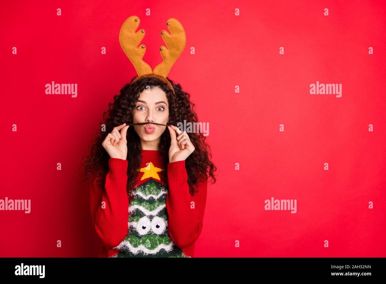 Photo de drôle de dame moustache avec un curl agissant aimé guy veulent gagner concours de costume porter le chandail avec cornes rouge isolé de l'arbre vert Banque D'Images