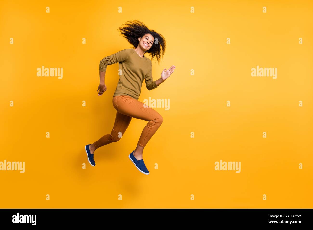 La taille du corps sur toute la longueur de la photo belle attrayante  positive charmante jolie fille portant des pantalons pantalon orange  tournant vers saut vide Photo Stock - Alamy