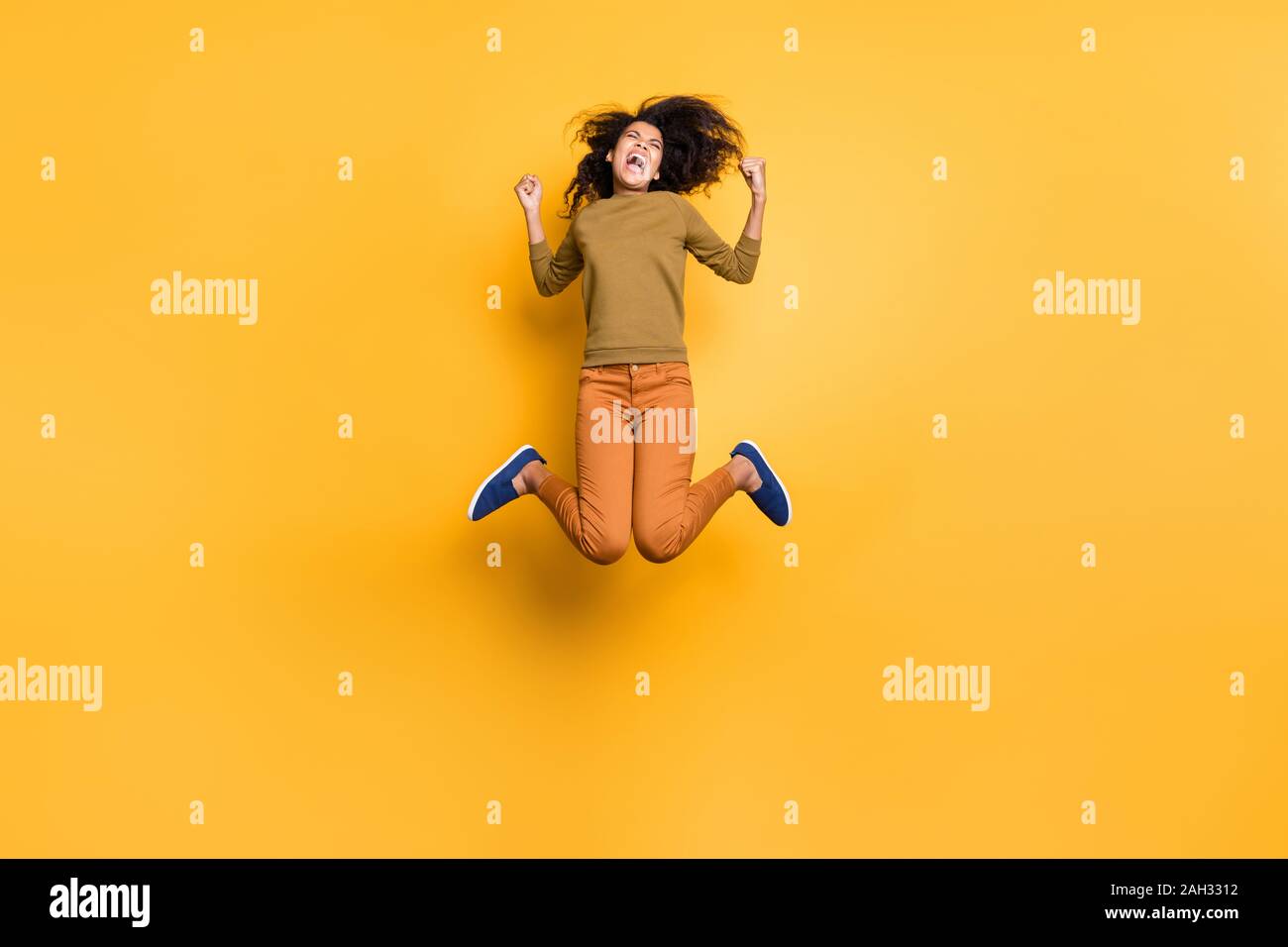 La taille du corps sur toute la longueur de la photo mignon positive extatique excité copine ondulées bouclés se réjouir d'avoir gagné un concours orange Banque D'Images