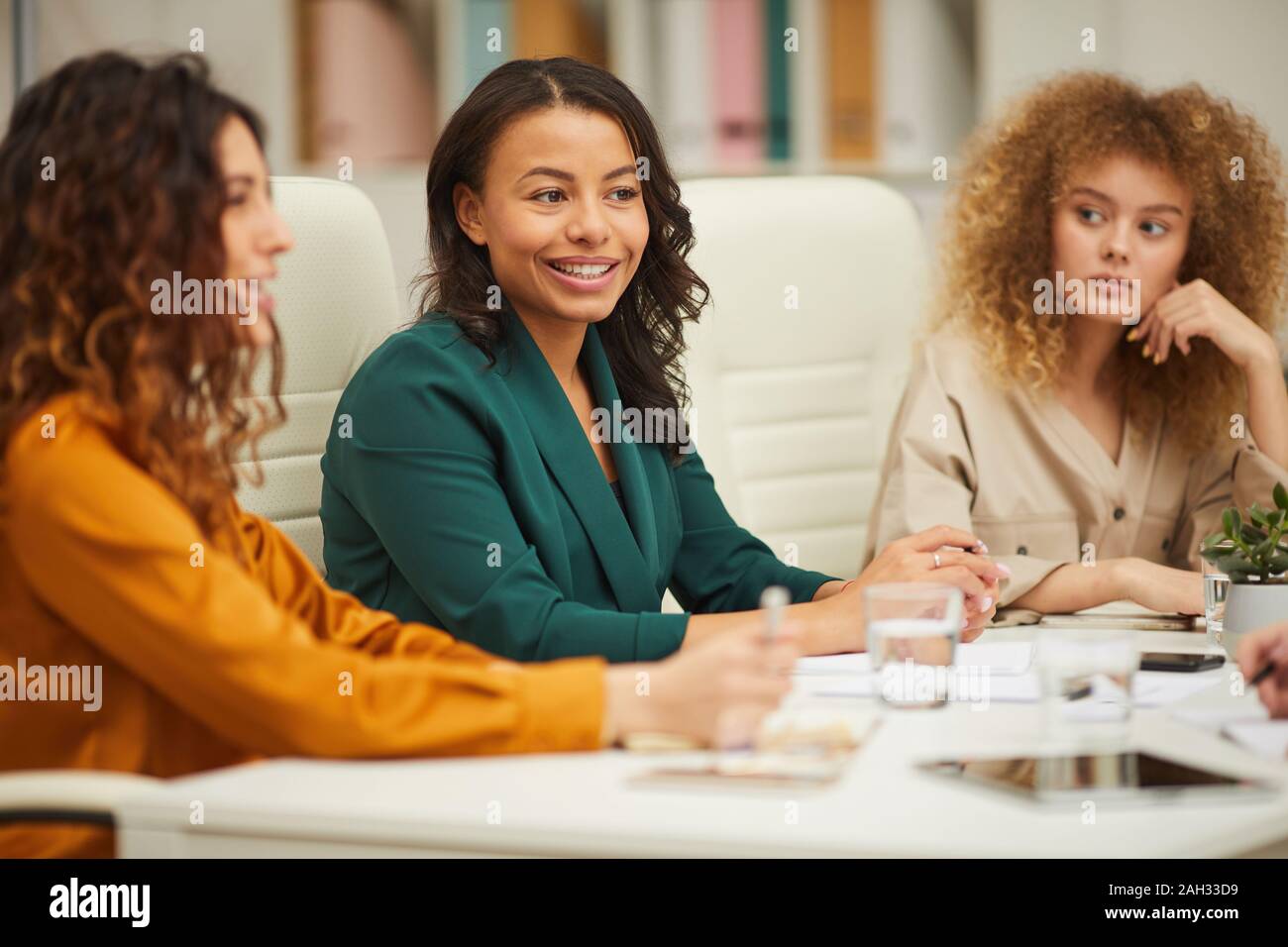 Trois charmantes multi-ethnic businesswomen having meeting in tir horizontal Banque D'Images