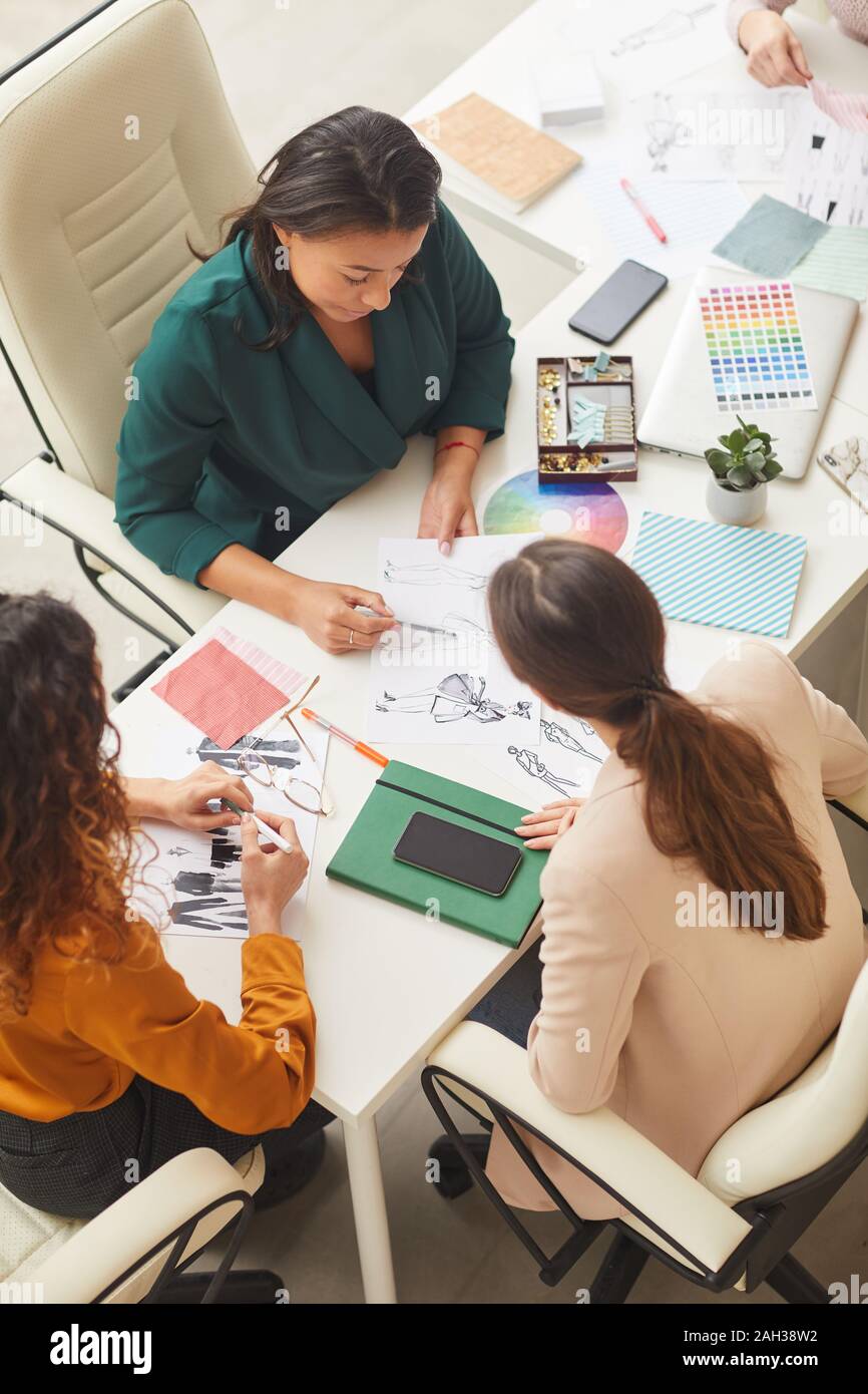 Groupe d'ethnies diverses jeunes femmes travaillant sur la conception des vêtements ensemble concept tourné l'angle vertical haut Banque D'Images