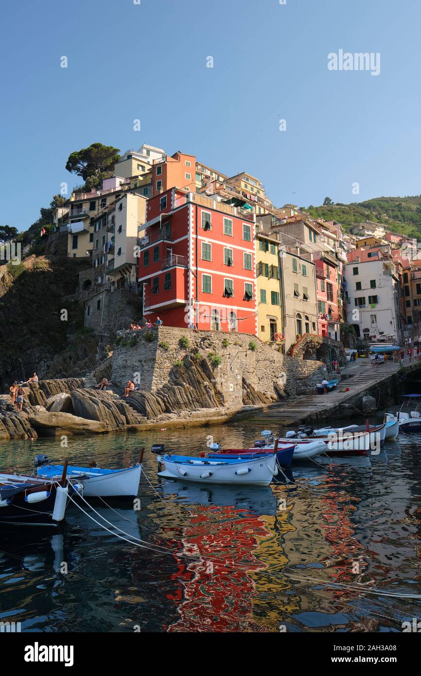 Les maisons peintes de couleurs vives et des petits bateaux de pêche dans le port du village de Riomaggiore, Cinque Terre National Park, Ligurie Italie UE Banque D'Images