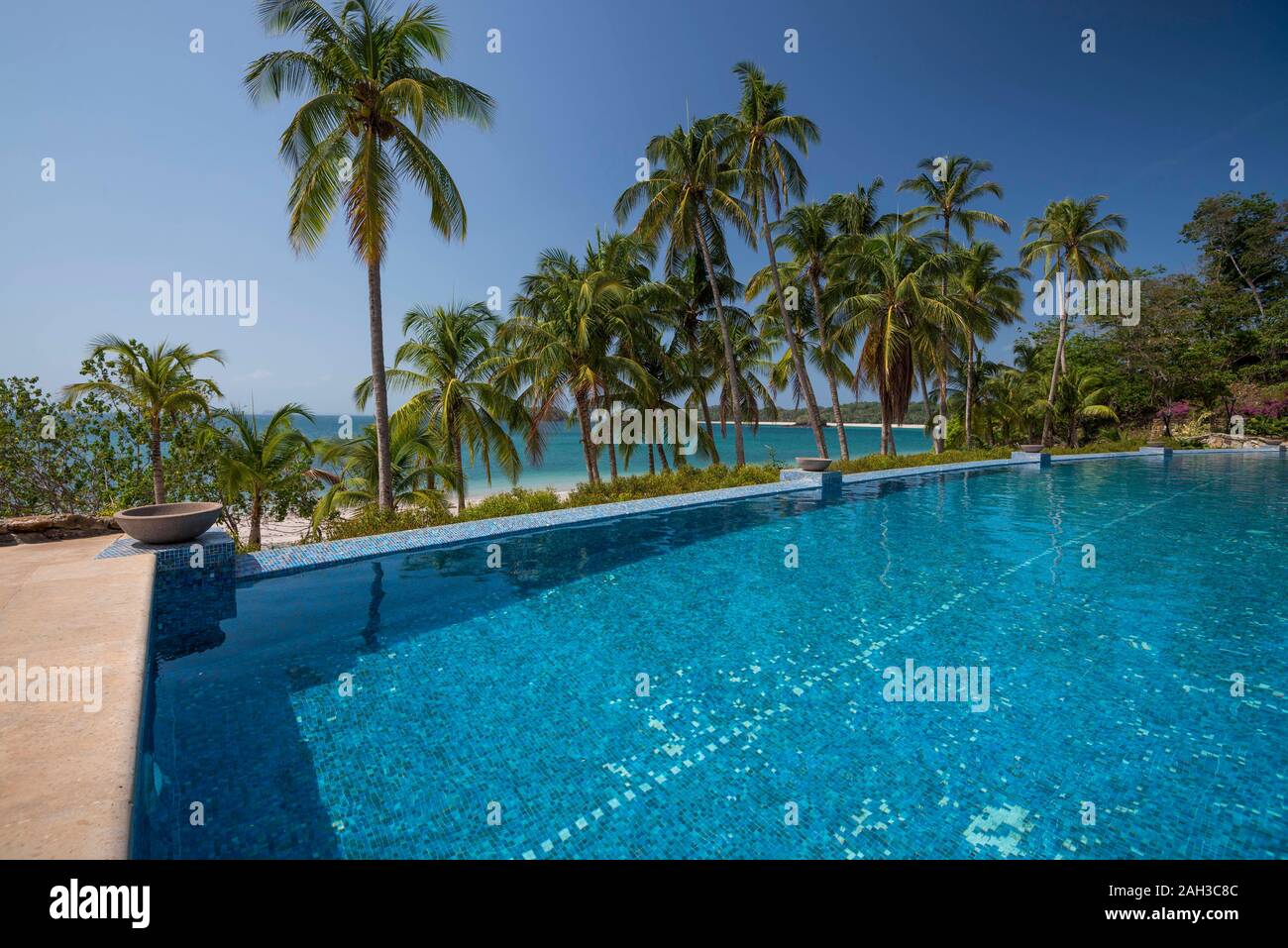 Une piscine à débordement entre les palmiers sur la plage sur l'océan Pacifique, l'archipel de las Perlas, Panama, Amérique Centrale Banque D'Images