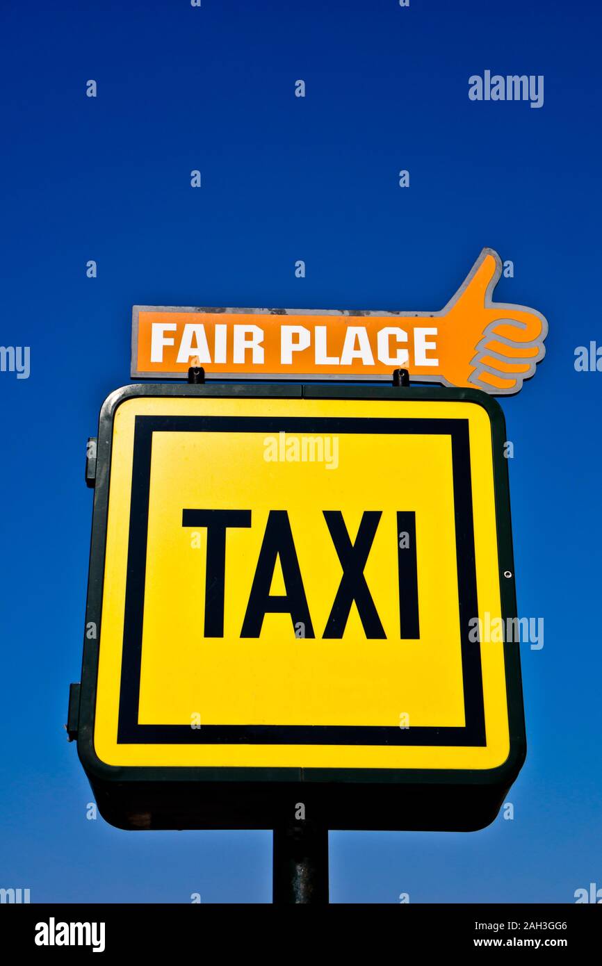 Panneau jaune pour taxi service sur un ciel bleu Banque D'Images